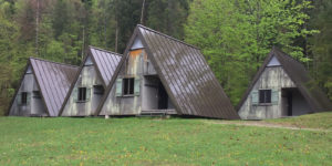 Ein Foto mit mehreren kleinen Gebäuden in Zelt Optik auf grüner Wiese