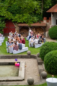 Gäste sitzen im Französischen Garten in der Burg Schwaneck