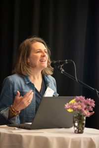 Sarah Stadler, stellvertretende Jugendamtsleiterin im Landkreis München steht vor dem Mikrofon und spricht Grußwort. 